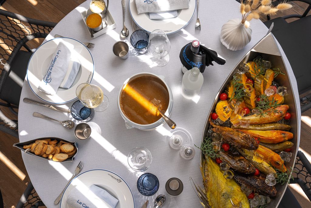 Le bouillon et le plat de poissons sur la table